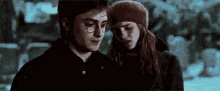 harry potter and hermione granger are standing next to each other in a cemetery .