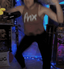 a woman is dancing in front of a shure microphone in a room