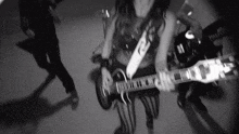 a woman is playing a guitar in a band in a black and white photo .