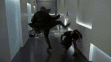 a group of people are walking down a hallway in a building