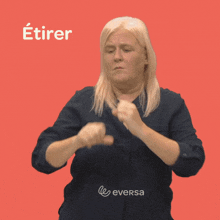 a woman in a blue shirt is making a gesture that says " etirer "