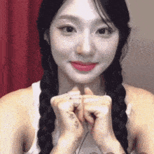 a woman with braids and a tattoo on her wrist is smiling .