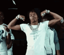 a man in a white shirt is flexing his muscles in front of a crowd