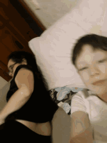 a boy and a woman are laying on a bed together