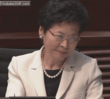 a woman wearing glasses and a pearl necklace is on youtube