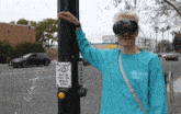 a man wearing goggles and a gallery dept shirt stands next to a pole