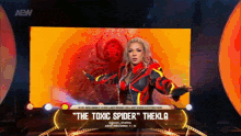 a woman is standing on a stage in front of a large screen that says the toxic spider .
