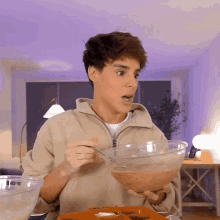 a young man is holding a bowl of food in his hands