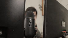 a black microphone is sitting in front of a samsung monitor