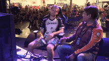 two men are sitting in front of a crowd and one is wearing a shirt that says prandi