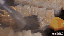 a close up of a person cooking shrimp on a pan