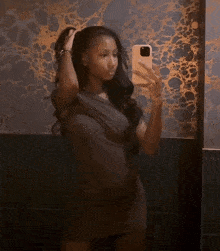 a woman taking a selfie in front of a mirror