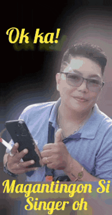 a man wearing glasses is holding a cellphone and giving a thumbs up