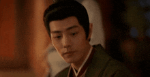 a close up of a man wearing a kimono and a crown .