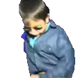 a young boy wearing a blue jacket is looking down .