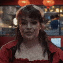 a woman in a red jacket is smiling with her eyes closed