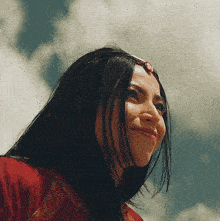 a woman wearing a red dress and a headpiece smiles