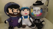 three stuffed toys are sitting next to each other including a tv head