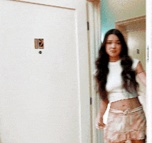 a woman is standing in front of a door with a sticker on it that says 12