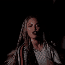 a close up of a woman with braids in her hair .