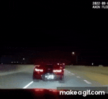 a screenshot of a car driving down a highway at night with make a gif.com at the bottom .