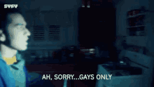 a man in a blue jacket is standing in a dark room and saying `` ah sorry ... gays only '' .