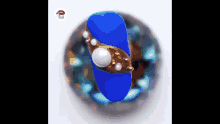 a close up of a blue nail with gold and pearls on it