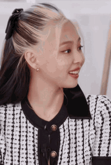 a woman wearing a black and white striped shirt and earrings
