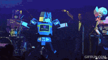 a man in a robot costume is dancing on a stage with gifrun.com in the corner