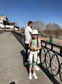 a girl wearing a white nike hat stands next to a man