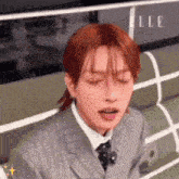 a man with red hair is wearing a suit and tie and making a funny face