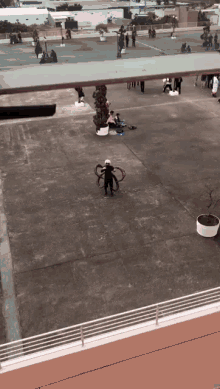 a man is playing with a hula hoop in a plaza
