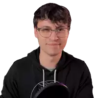 a man wearing glasses and a black hoodie smiles for the camera