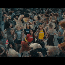 a group of women are dancing in a crowd with one wearing a shirt that says jump
