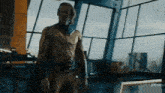 a man in a yellow and blue superhero costume is standing in front of a large window .