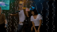 a man wearing a crown stands in front of a microphone while a woman stands behind him