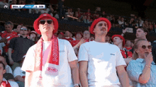 a group of people watching a game with bra 1 on the scoreboard