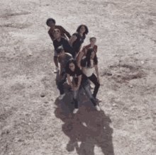 a group of people are posing for a picture in a dirt field