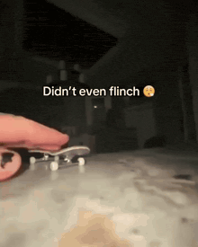 a person holding a skateboard with the words did n't even flinch written above it