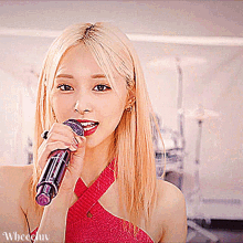 a woman singing into a microphone with the word wheen on the bottom left