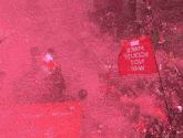 a crowd of people holding up a red flag that says raw on it