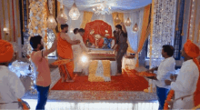 a group of people are standing around a statue of a deity