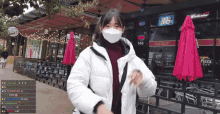 a woman wearing a mask is standing in front of a bud light sign