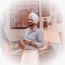a man wearing a turban is holding a piece of paper in his hand