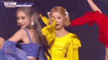 a woman in a yellow dress is dancing on a stage in front of a banner that says show champion