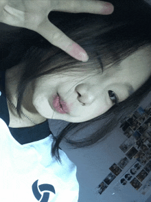 a girl making a peace sign with her hand