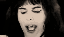 a black and white photo of a woman 's face with her eyes closed