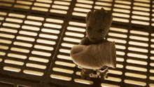 a baby groot is being held by a person 's arm