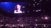 a large screen shows a woman singing into a microphone