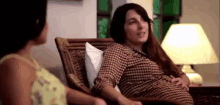 a pregnant woman is sitting in a chair with another woman .